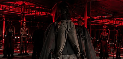 Models in an installation under red lighting